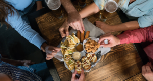 group of people reaching for appetizers on a platter
